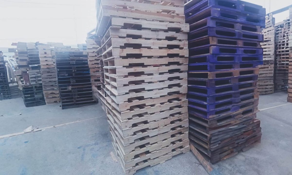 Estibas de tarimas de madera y plástico en patio